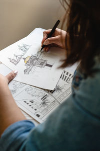 High angle view of woman hand on paper