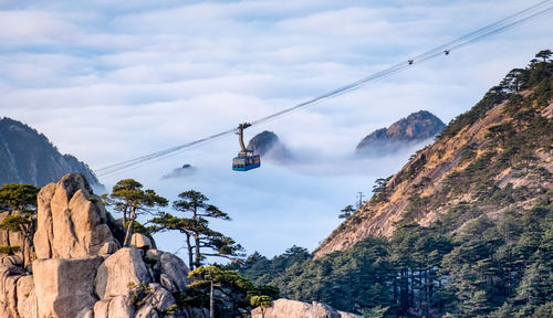 Low angle view of overhead cable car against sky