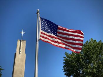 Low angle view of american flag against blue sky