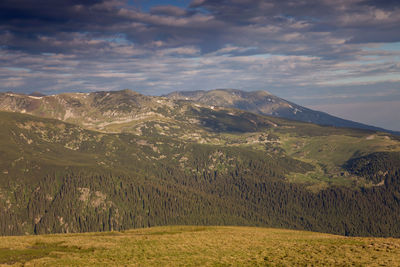 Scenic view of mountains against cloudy sky