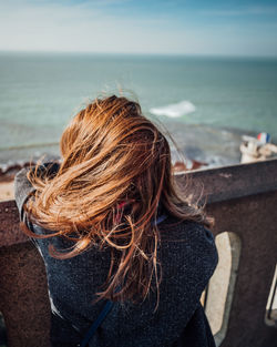 Rear view of woman looking at sea against sky