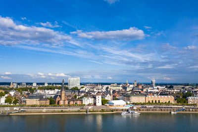 River amidst buildings in city against sky
