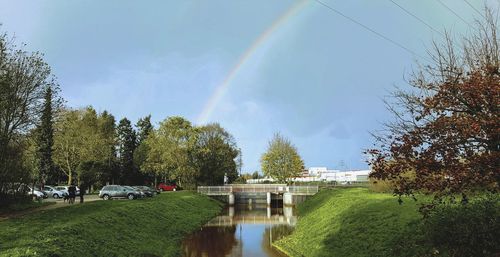 Scenic view of rainbow over river against sky