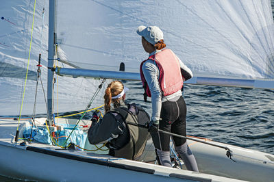 Rear view of people on boat sailing in sea