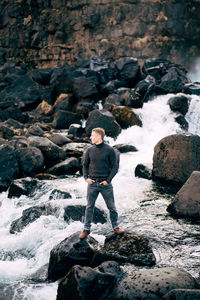 Full length rear view of man standing on rock