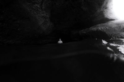 Man standing on rock by water