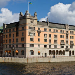 Buildings in city against cloudy sky