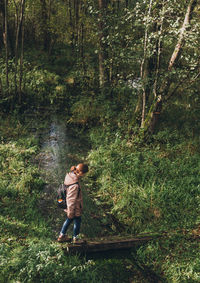 High angle view of young woman hiking in forest