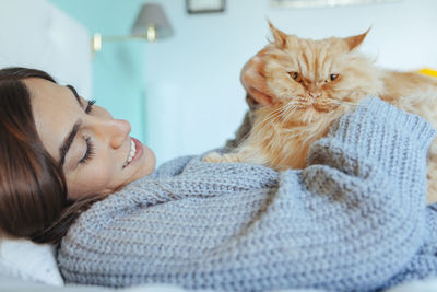 Portrait of cat relaxing on bed at home