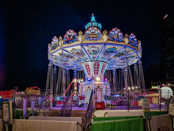 Illuminated ferris wheel at night