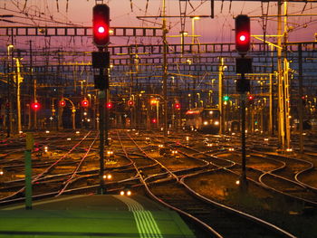 Train on illuminated railroad tracks against sky