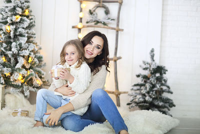 Woman with daughter sitting on plant