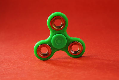 Close-up of fidget spinner on red table