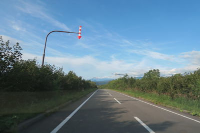 Road amidst trees against sky