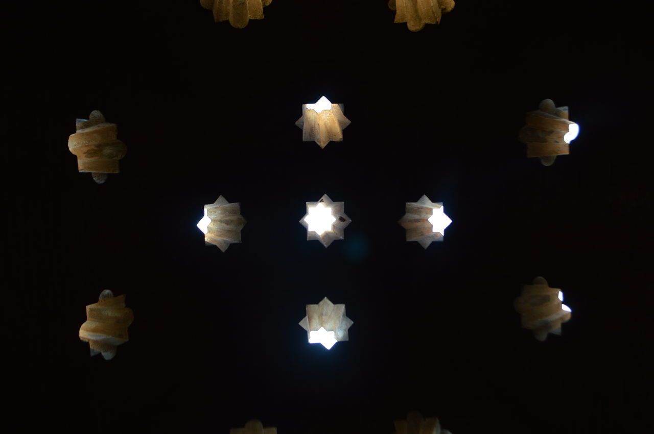 CLOSE-UP OF ILLUMINATED LIGHTS OVER BLACK BACKGROUND