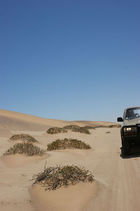 Scenic view of desert against clear blue sky