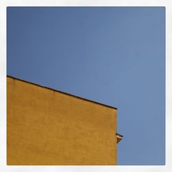 High section of building against clear blue sky