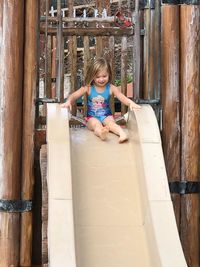 Happy girl sitting on slide