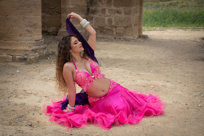 Woman performing belly oriental dancing wearing coloured costume. dancing outdoors