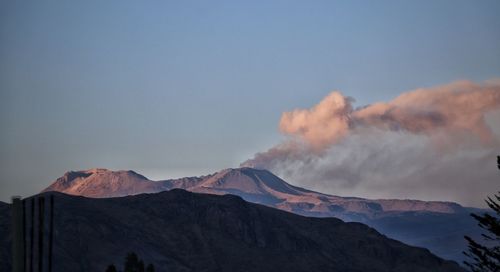 Smoke emitting from volcanic mountain against sky