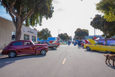 Cars on road in city against sky