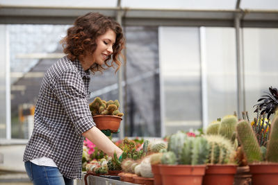 Woman working over plants in greenhouse