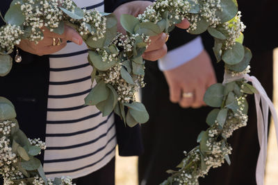 Midsection of woman holding bouquet of flowering plants