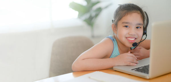 Portrait of girl using mobile phone at home