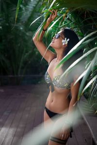 Young woman standing against tree