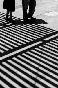 Low section of people on street with shadow