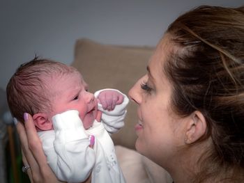 Mother carrying daughter at home