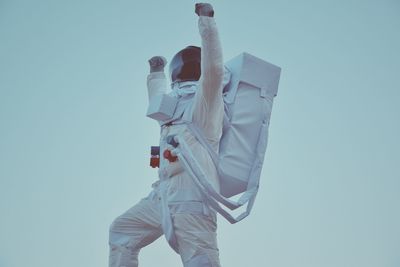 Low angle view of astronaut statue against clear sky