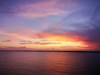 Scenic view of sea against dramatic sky during sunset