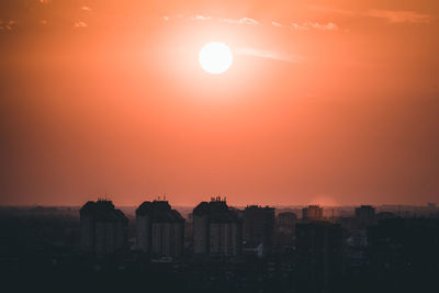 Silhouette buildings against sky during sunset