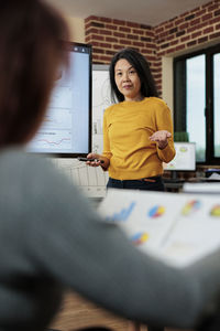 Portrait of young woman using laptop on table