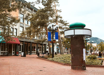 Street amidst trees and buildings against sky