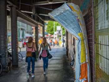 Rear view of people walking on footpath