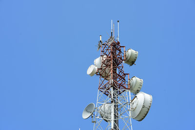 Low angle view of communications tower against clear blue sky