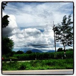 Scenic view of field against cloudy sky