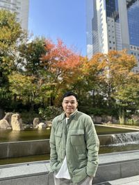 Portrait of young man standing against buildings