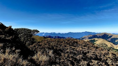 Scenic view of mountains against blue sky