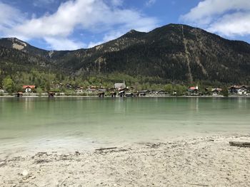 Scenic view of lake by mountains against sky