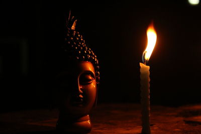 Close-up of lit candle in the dark