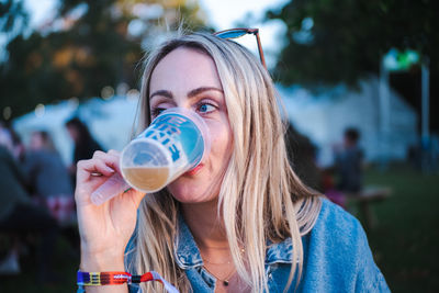 Blond woman drinking craft beer at festival