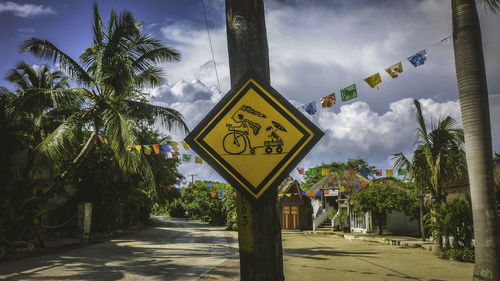 Road sign against cloudy sky