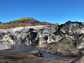 Scenic view of mountains against clear blue sky