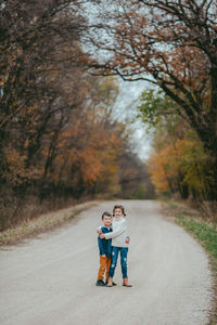 Boys on road amidst trees