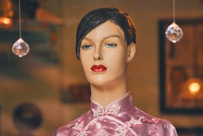 Mannequin in traditional clothing seen through glass