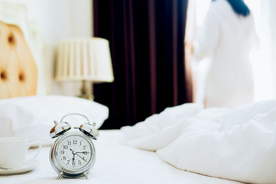 Close-up of alarm clock on bed