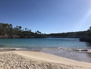 Scenic view of beach against clear blue sky